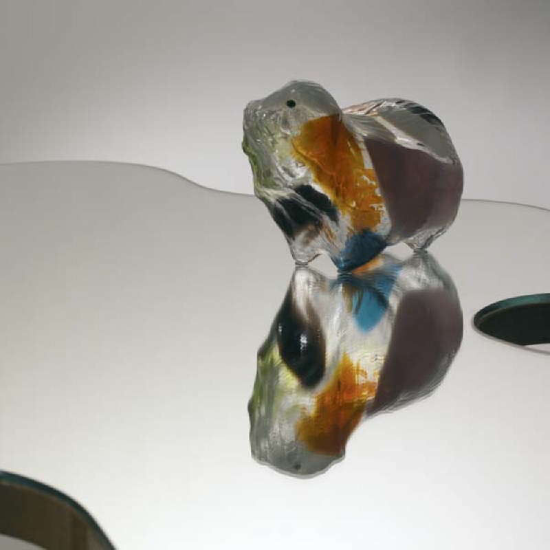 Glasskulptur i form av en lämmel, ingår i konstverk tillsammans med bord NMK 9a/2004.