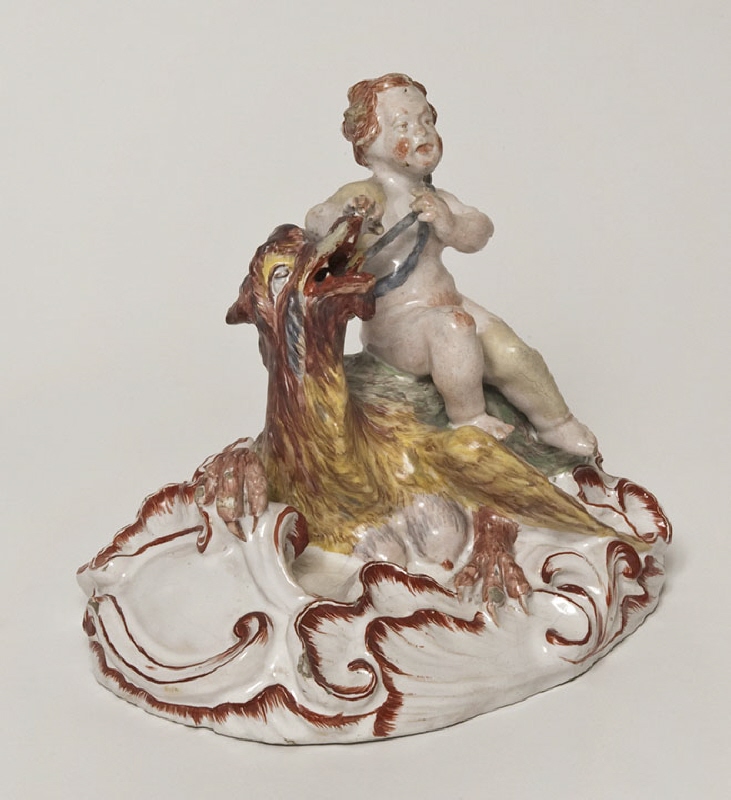 Figurin Amor sittande på en drake