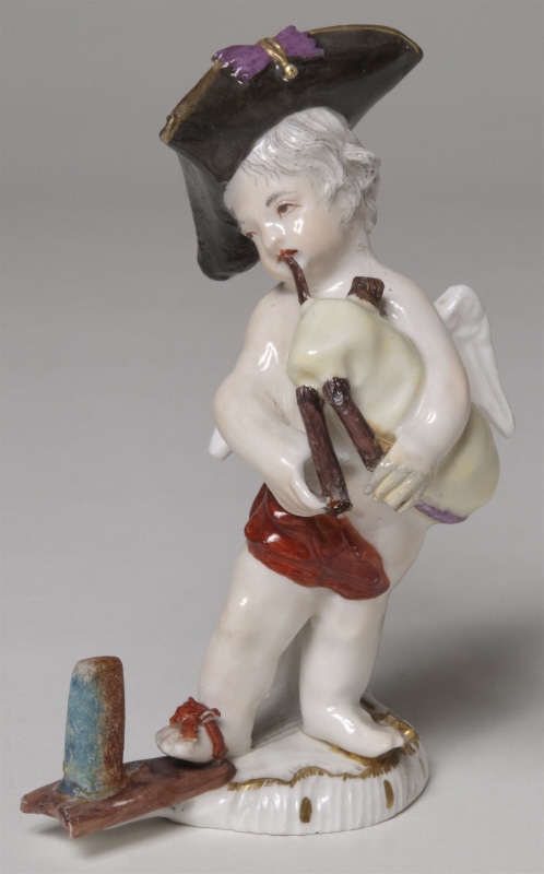 Figurin, bevingad putto som säckpipblåsare