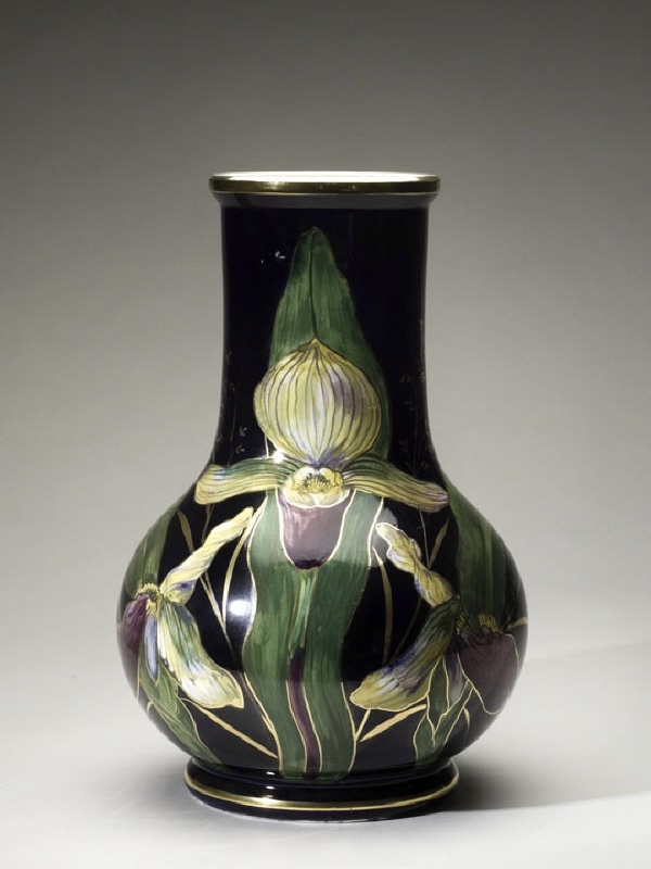Vas/urna med iris, gräs och fjäril i flera färger