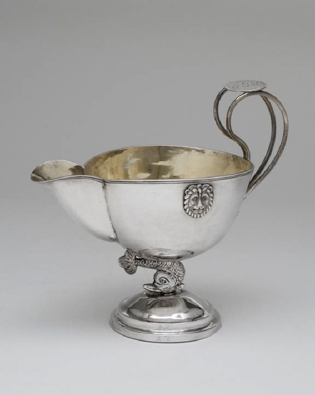 Cream jug in the shape of a bowl resting on a dolphin