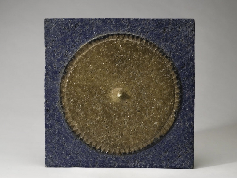 Platta med brun cirkel i relief