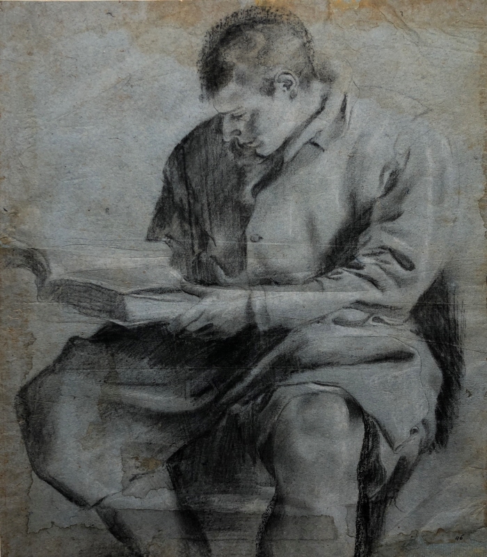 Ung sittande man läsande en bok